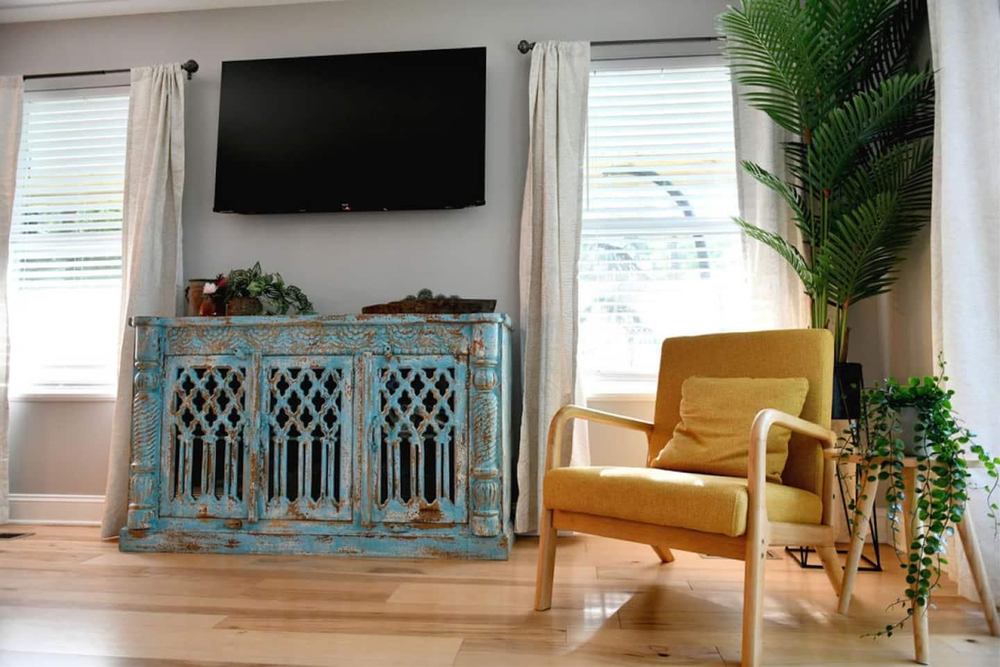 Living room with a painted blue console and yellow chair
